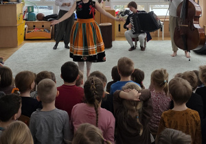 Dzieci poznają różne tańce narodowe - oglądają, jak Szeptucha tańczy oberka.