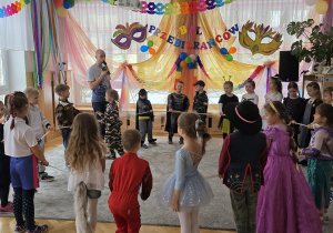 Dzieci rywalizują podczas zabawy z gumą na balu.