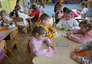 Dzieci wykonują zadanie warsztatowe - szczęśliwe/radosne serce.