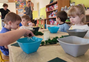 Dzieci tworzą makietę miejsca w którym zamieszka ich dinozaur.