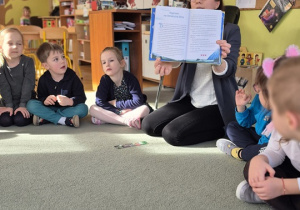 Mama Antosia pokazuje ilustracje w książce.