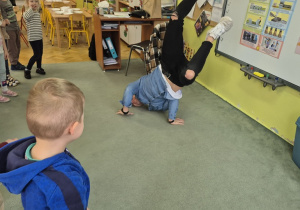 Tata Huga pokazuje figurę z breakdance.