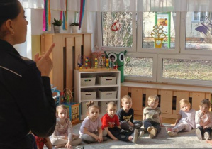 Pani policjantka przypomina dzieciom o obowiązku siedzenia w foteliku w czasie jazdy samochodem.