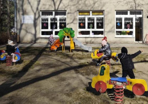 Dzieci bawią się wykorzystując sprzęt ogrodowy.