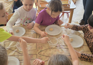 Dzieci za pomocą pipety i octu wyszukują szczątków dinozaurów.