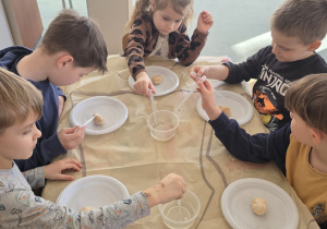 Dzieci za pomocą pipety i octu wyszukują szczątków dinozaurów.