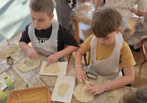 Dzieci tworzą wykopaliska ze szczątkami dinozaurów.