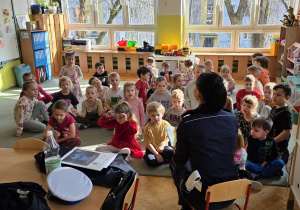 Pani Policjantka czyta dzieciom książeczkę.