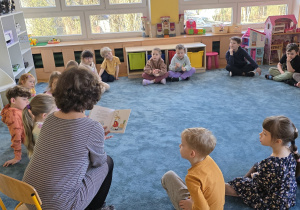 Dzieci słuchają książeczki pt. "pt. "Gucio nie może się skupić".