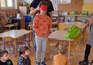 Chłopiec rozwiązuje zagadkę dotykową. Ma przy tym zasłonięte oczy.