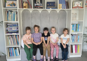 Dziewczynki siedzą na kanapie w bibliotece.