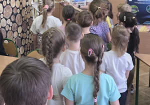 Dzieci odwiedzają salę biologiczną i witają się z kostkiem.