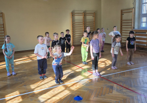 Dzieci biorą udział w zabawie "do przodu - do tyłu".