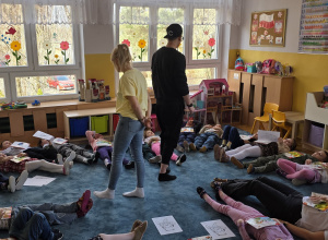 Dzieci leżą n dywanie i oddychają wg wytycznych.