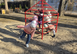 Dzieci bawią się na drabinkach.