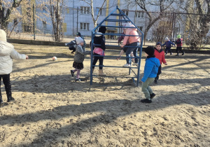 Dzieci biegają po ogrodzie.