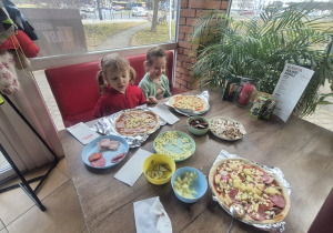 dziewczynki czekają żeby upiec swoje Pizze.