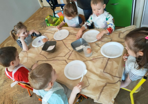 Dzieci obserwują jak zachowuje się jajko włożone do solanki.