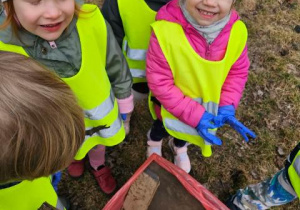 Dzieci prezentują swój worek wypełniony różnymi znaleziskami.