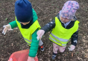 Dzieci wrzucają zebrane śmieci .