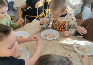 Chłopcy za pomocą pipety i octu wyszukują szczątków dinozaurów.