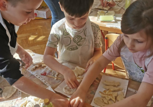 Dzieci tworzą wykopaliska ze szczątkami dinozaurów.