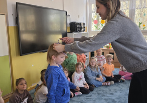 Pani doktor wręcza chłopcu medal za wiedzę nt. pracy stomatologa.