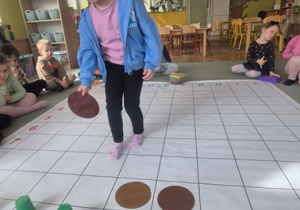 Dziewczynka układa na macie do kodowania różne elementy.