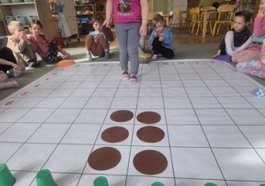 Dziewczynka rozmieszcza na macie do kodowania kolejne elementy.