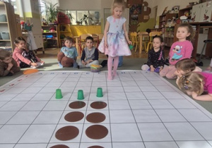 Dziewczynka rozmieszcza na macie do kodowania różnorodne elementy.