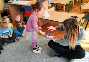 Dziewczynka pokazuje jak należy myć zęby.