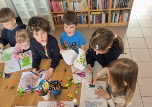 Dzieci z zaangażowaniem tworzą swoje prace plastyczne.