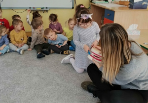 Dziewczynka przy pomocy Pani Agaty pokazuję jak prawidłowo myć zęby.