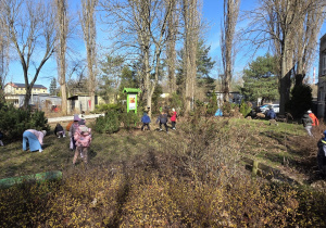 Dzieci szukają w magicznym ogrodzie ukrytych jajek.
