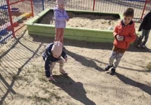 Dzieci zbierają jajeczka w ogrodzie.