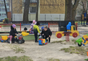 Grupka dzieci bawiących się na placu zabaw.