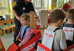 Dzieci udają pojazdy w ruchu drogowym.