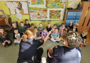 Dzieci uważnie słuchają i odpowiadają na pytania.