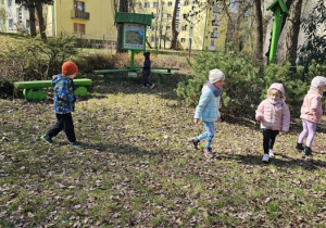 Dzieci biegają po ogrodzie i szukają wielkanocnych jajeczek