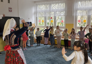 Dzieci tańczą wspólnie krakowiaka.