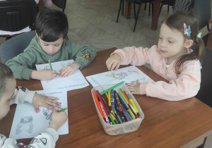 Dzieci kolorują obrazek konturowy.