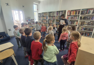 Pani z biblioteki prezentuje książkę, którą będzie czytać