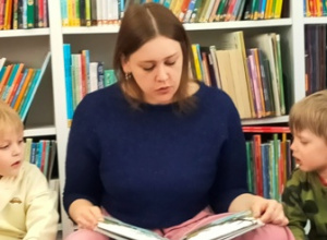 Pani bibliotekarka czyta dzieciom bajkę.