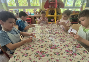 Dzieci ozdabiają swoje pudełka kolorowymi naklejkami
