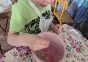 Chłopiec dosypuje ozdoby do slime'a