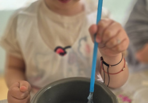 Dziewczynka tworzy balon dmuchając do środka slime'a