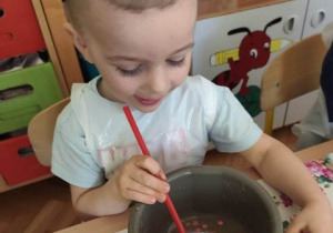 Chłopiec podziwia stworzonego przez siebie glutkowego bąbelka.