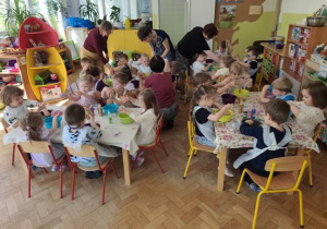 Dzieci gniotą rękami w miseczkach otrzymaną masę plastyczną.