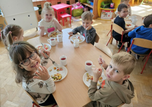Dzieci ze smakiem degustują własnoręcznie przygotowaną sałatkę