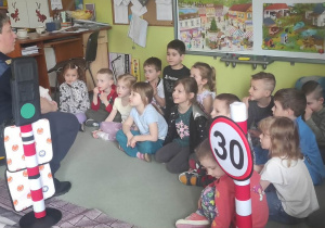 Dzieci rozmawiają z funkcjonariuszkami Straży Miejskiej na temat bezpieczeństwa w ruchu drogowym.